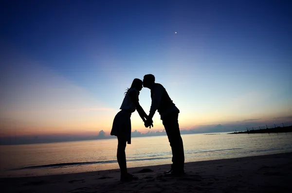 Hombre besándose mujer en la frente, silueta antes del amanecer . — Foto de Stock