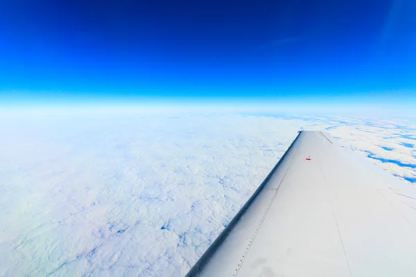 Prachtig uitzicht van het vliegtuig naar de wolken en de aarde — Stockfoto