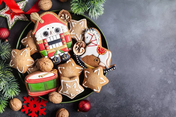 크리스마스 진저브레드 쿠키는 어두운 배경에 세라믹 접시에 호두까기 스톡 사진