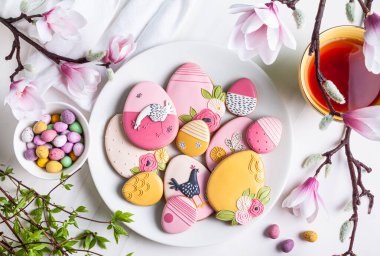 Beyaz arka planda beyaz bir tabakta el yapımı Paskalya kurabiyesi ve çikolatalı yumurta..