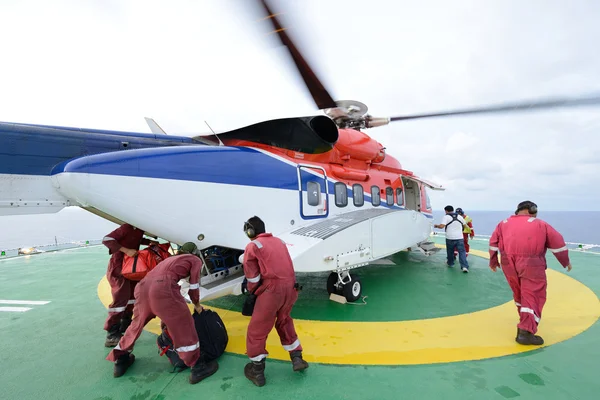 El oficial de aterrizaje del helicóptero está cargando equipaje y pasajeros —  Fotos de Stock