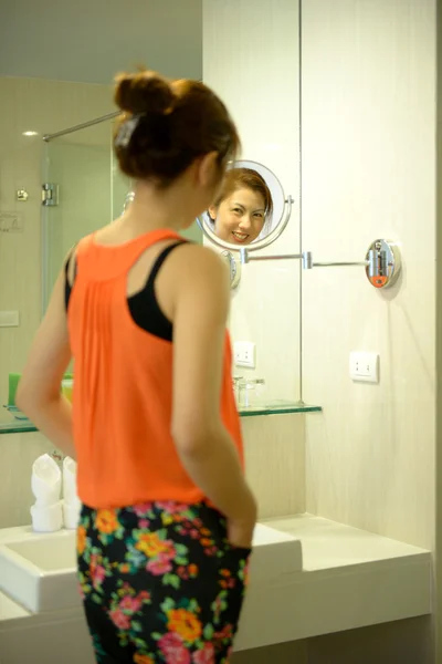 Schöne asiatische Frau lächeln mit einem Spiegel — Stockfoto