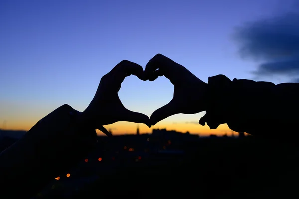 Silueta de manos en forma de corazón cuando los novios tienen tacto — Foto de Stock