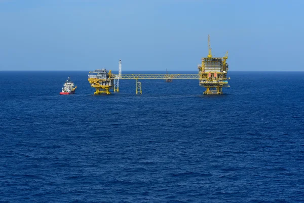 Морская нефтяная вышка и судно снабжения — стоковое фото