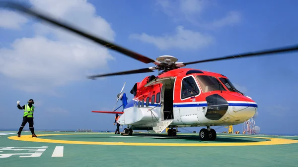 The helicopter landing officer give signal to passenger to embar — Stock Photo, Image