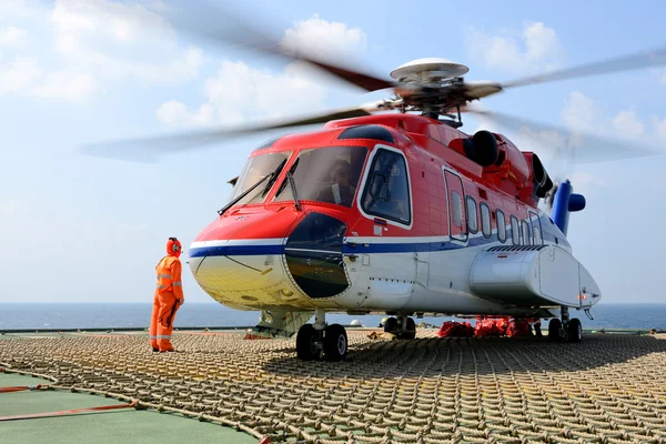 Der Hubschrauberlandeoffizier kümmert sich um das Verladen des Gepäcks in den Heli — Stockfoto