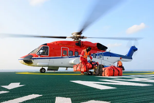 Helikopter landning officeren laddar bagage till helikopter på — Stockfoto