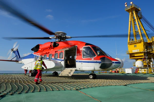 El oficial de aterrizaje del helicóptero va a helicóptero en la plataforma petrolera — Foto de Stock