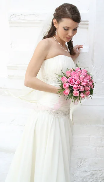 Bride looking at bouquet — Stock Photo, Image