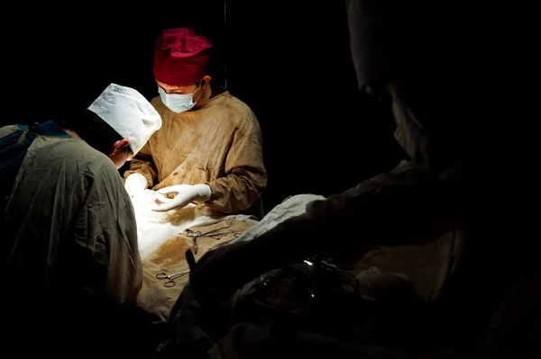 어둠 속에서 일 하는 외과 의사 로열티 프리 스톡 이미지