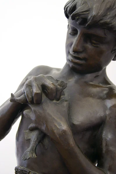 Una estatua de bronce de un niño pescador — Foto de Stock