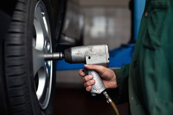 Automechaniker wechselt Rad — Stockfoto