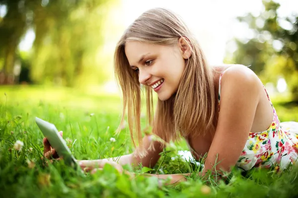 Mujer joven usando tableta al aire libre — Foto de Stock