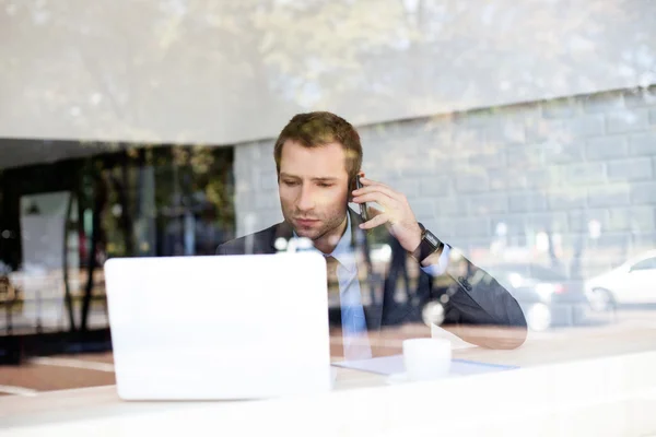 Бизнесмен разговаривает по телефону в кафе — стоковое фото
