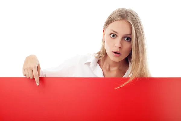 Überraschte junge Frau zeigt auf Plakatwand — Stockfoto