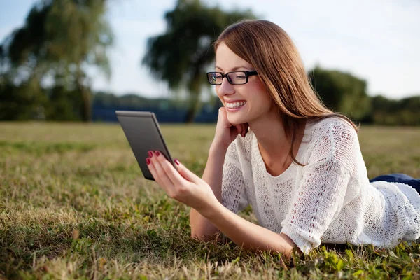 Junge Frau liest E-Book in der Natur — Stockfoto