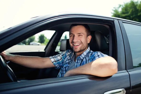 Mladý muž v automobilu s úsměvem — Stock fotografie