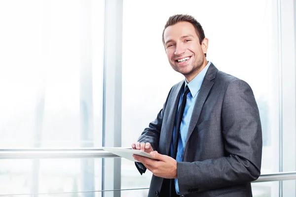 Empresário com tablet digital sorrindo — Fotografia de Stock