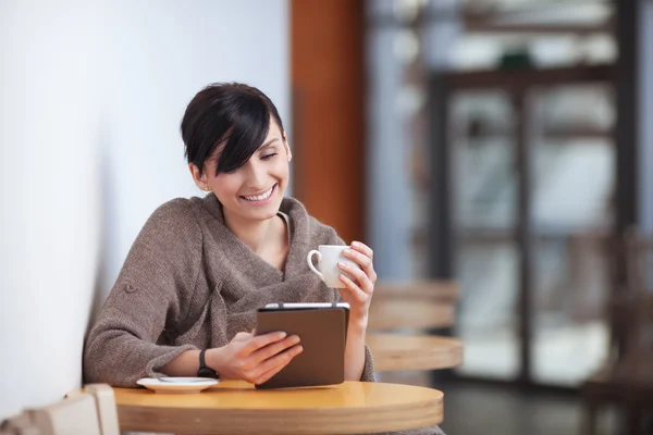 Junge Frau sitzt mit digitalem Tablet im Restaurant — Stockfoto