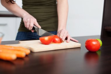 Food preparation. Woman cutting red tomato