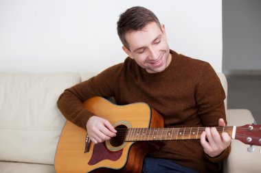 Gitar çalan yakışıklı genç adam.