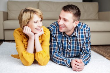 mutlu genç bir çift evde halı üzerinde yalan