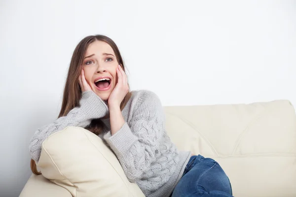 Jonge vrouw schreeuwt tijdens het kijken naar televisie — Stockfoto