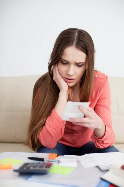 Mujer estresada mirando facturas — Foto de Stock