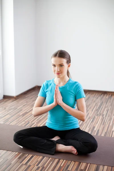 Mujer joven practicando yoga en casa —  Fotos de Stock