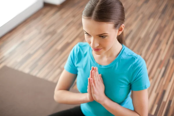 Jonge vrouw die thuis yoga oefent — Stockfoto