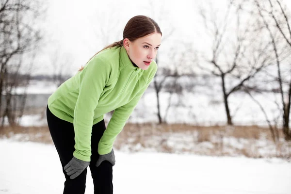 Giovane donna a riposo dopo la corsa in inverno — Foto Stock