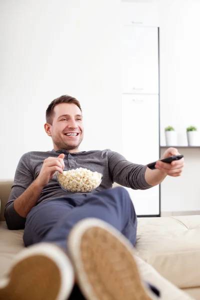 Uomo single sul divano a guardare la TV — Foto Stock