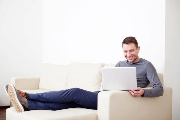 Man sitter på soffan med digital tablet — Stockfoto