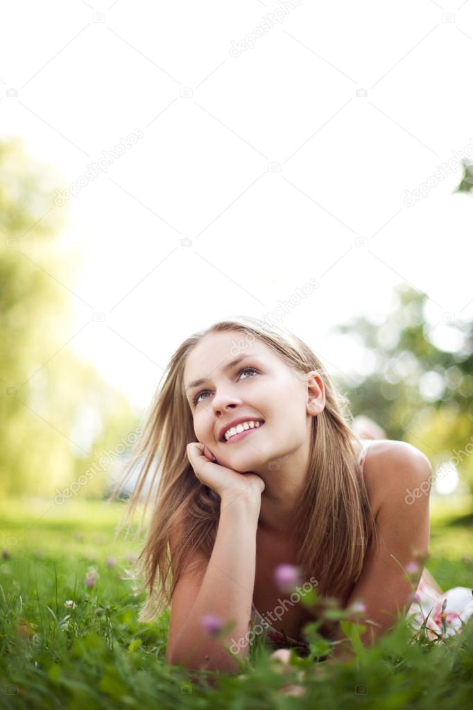 Beautiful young woman lie on grass