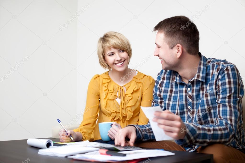 Happy young couple paying bills