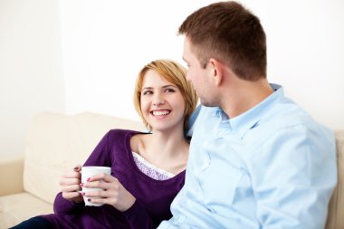 Çift kanepede birlikte oturuyor.