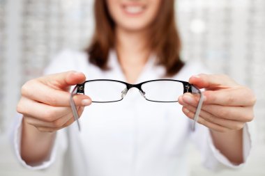 optometrist, optician giving glasses to try clipart