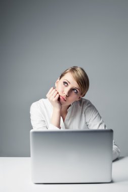 laptop ile oturan üzgün genç kadın
