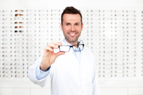 Felice optometrista, ottico che mostra occhiali — Foto Stock