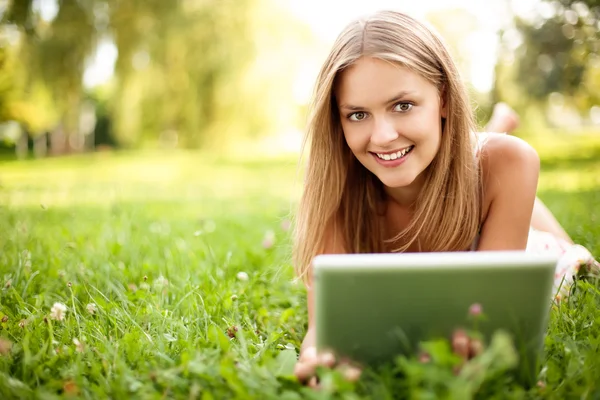 Jonge vrouw met digitale tablet op gras Rechtenvrije Stockfoto's