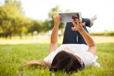 Tablet üzerinde çim döşeme açık kullanan kadın