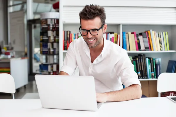 Glücklicher Mann, der mit Laptop arbeitet — Stockfoto