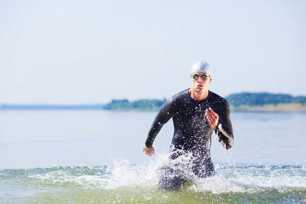 Triathlete running out of the water — Stock Photo, Image