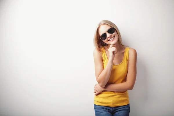 Mujer joven con camisa amarilla y gafas de sol — Foto de Stock