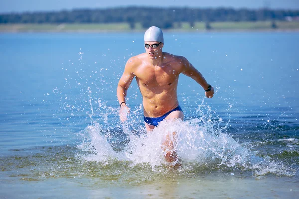 Traithlete corriendo fuera del agua — Foto de Stock