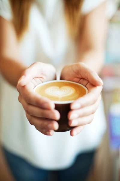Close-up van vrouwelijke geven koffie met hartsymbool — Stockfoto