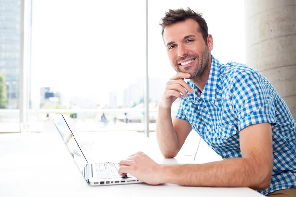 Glücklicher Mann, der mit Laptop arbeitet — Stockfoto