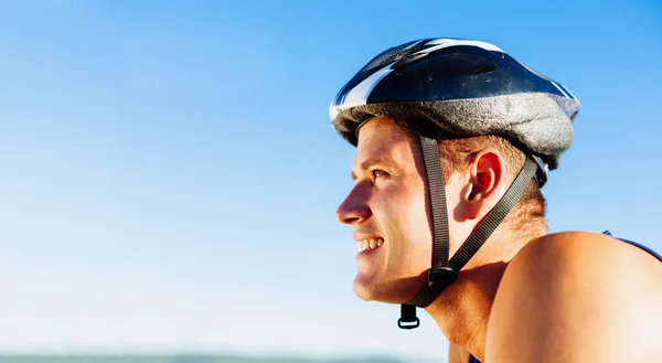 Молодой человек катается на велосипеде со шлемом — стоковое фото