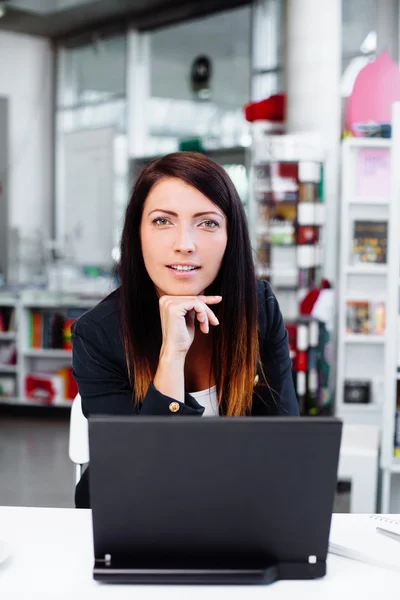 Business woman sitting in office with laptop — Stock Photo, Image