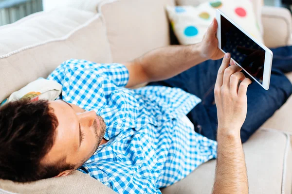 Hombre con tablet digital en el sofá — Foto de Stock